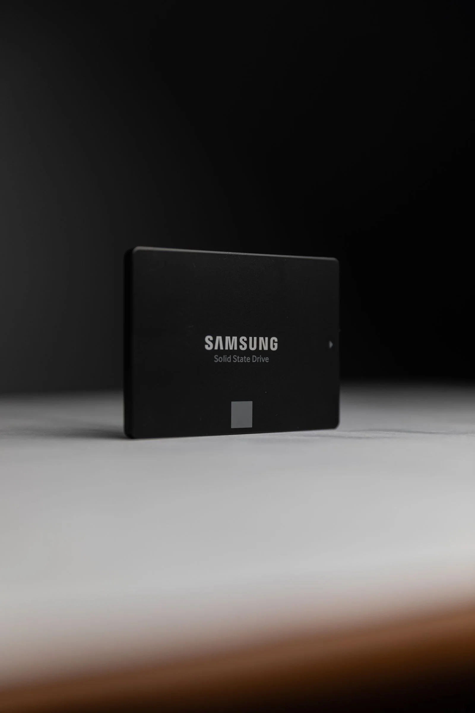 Black solid-state drive photographed on a neutral surface